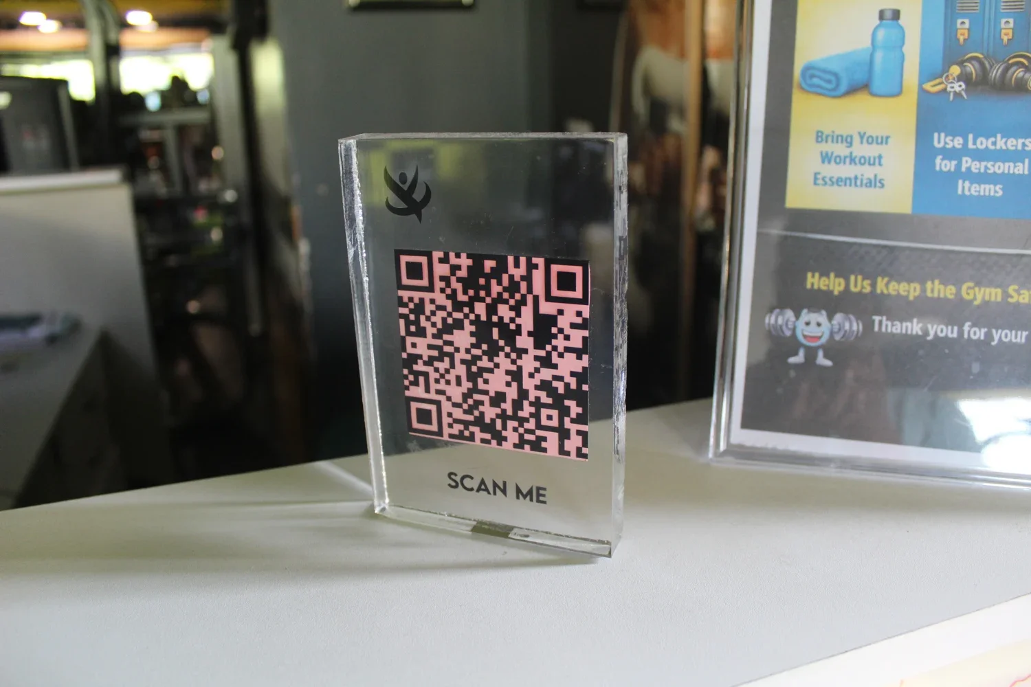 QR registration stand on a gym reception desk